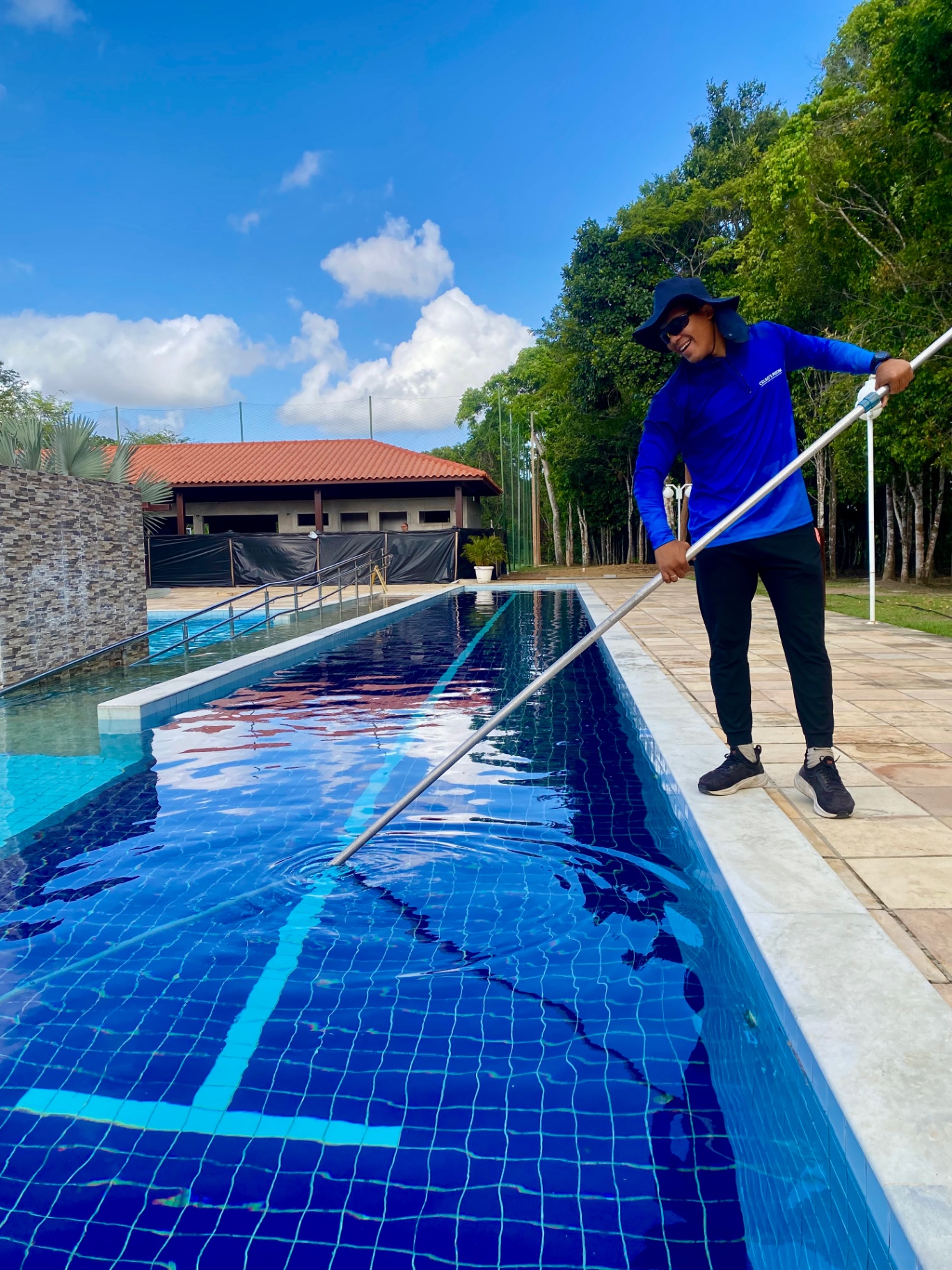 Funcionário da Celso's Piscinas realizando manutenção em piscina de raia de condomínio
