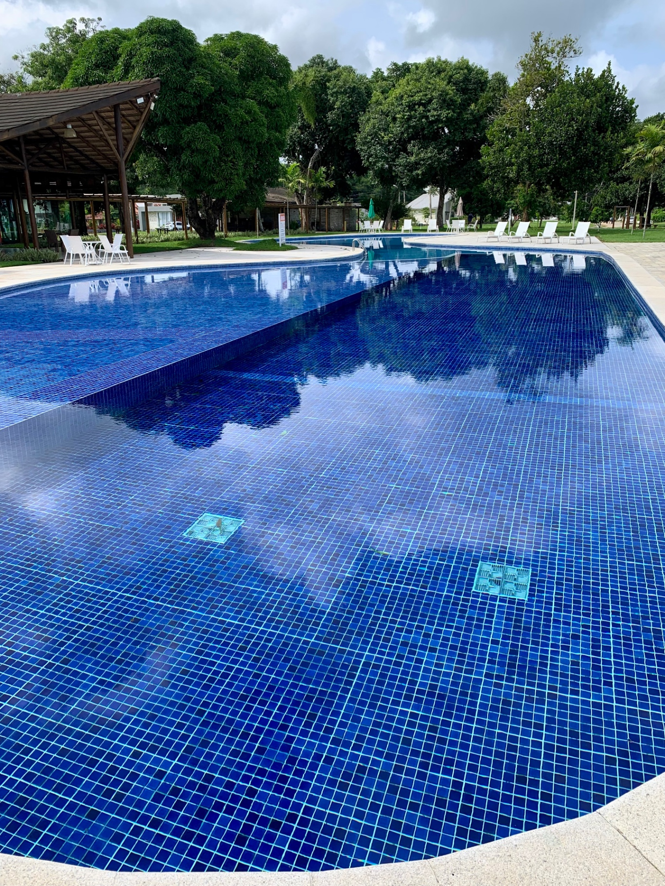 Piscina de grande porte em condomínio/clube com água cristalina