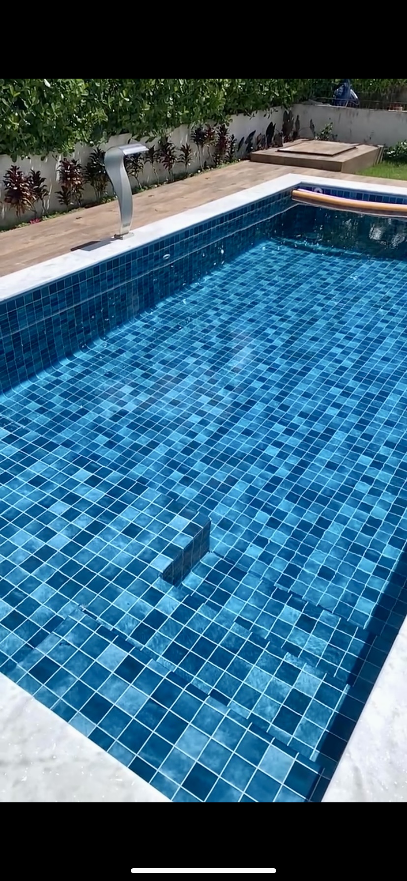 Piscina residencial moderna com pastilhas azuis e água cristalina