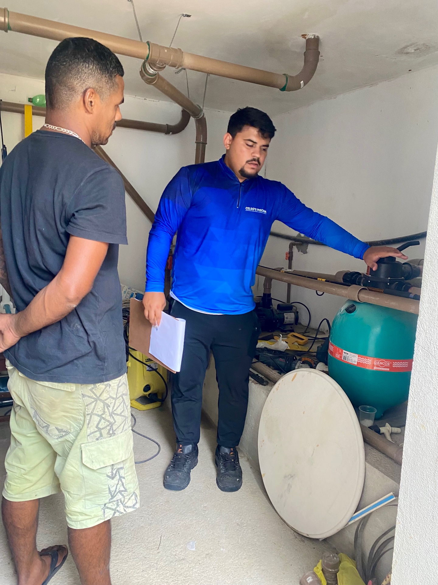 Técnico da Celso's Piscinas explicando a casa de máquinas ao cliente